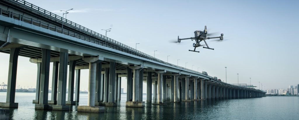 Drone flying in front of bridge